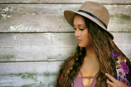 Girl in a hat standing and thinkingの写真素材