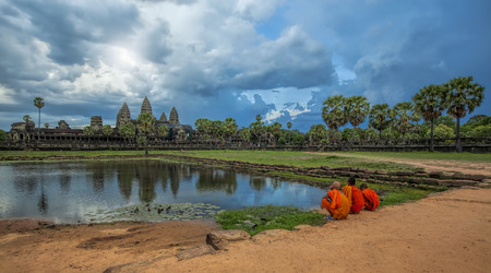 Monks watching the sunset over Angkor Wat from the lakeのeditorial素材