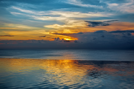 Balinese sunset with blue water and colorful skiesの写真素材