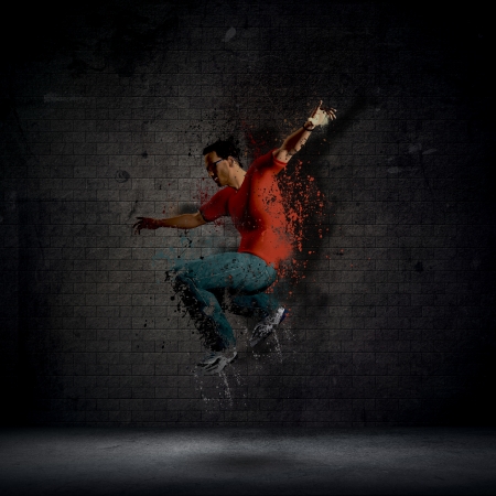 Abstract grunge man dancing against a dark brick wallの写真素材