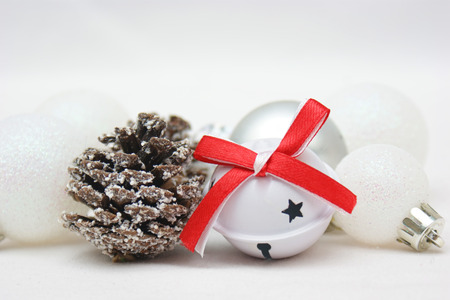 Christmas background with bell, pine cone and baublesの写真素材