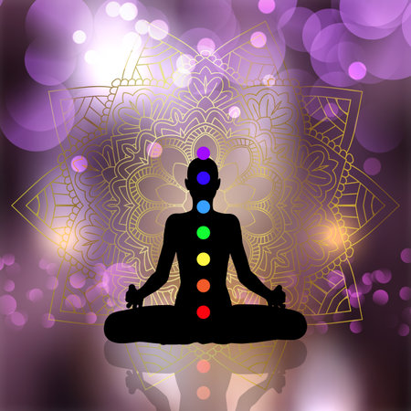 Silhouette of a female in yoga pose with chakra on decorative mandala background