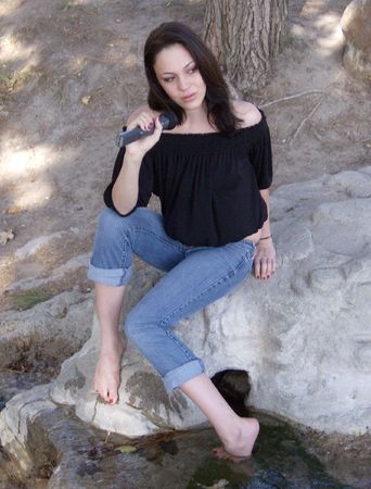 Young Woman with Microphone in Parkの写真素材