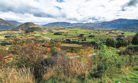 Looking at a landscape of farmland and mountains from a viewpoint near Wanaka on New Zealand's south island.の写真素材