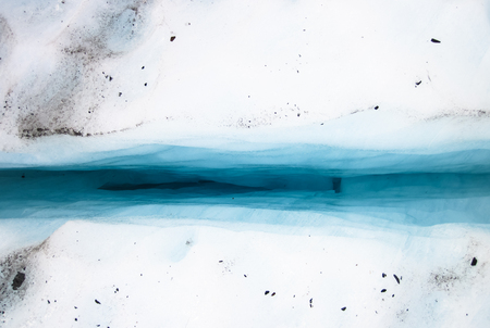 Looking down into a crevasse on the Fox Glacier, with deep blue colors coming from the ice. South island of New Zealand.の写真素材