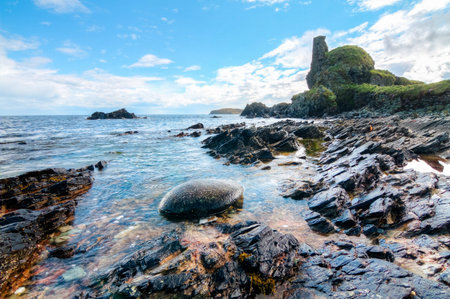 Jagged rock layers and boulders smoothed by the ocean are seen at an intertidal zone on the island...