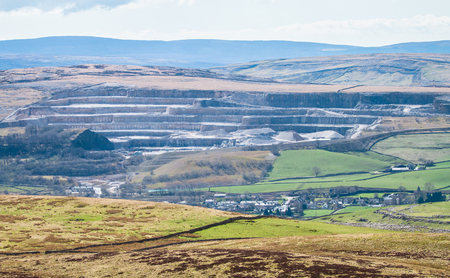 A massive rock quarry is seen from a distance in the Peak District, England.の写真素材