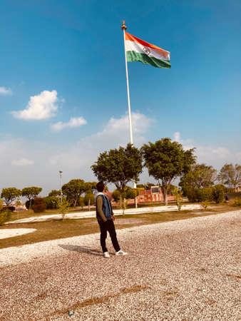 Man standing in front of the flag on a sunny day.の写真素材