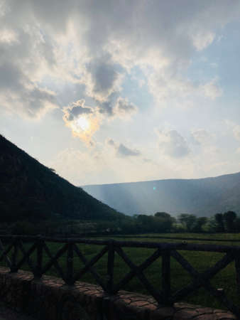 Sunset in the mountains. The sun breaks through the clouds.の写真素材
