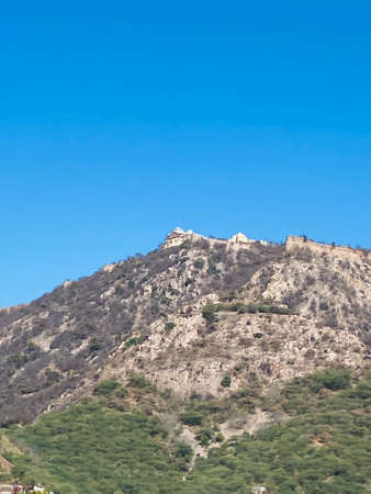Mountain landscape with a castle in the foreground and a blue skyの写真素材