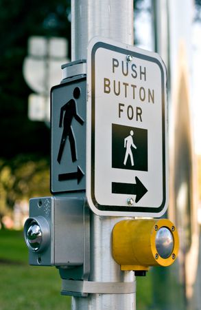 Crosswalk signs with yellow and silver buttonsの写真素材