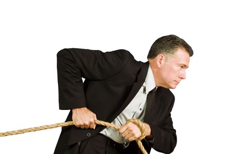 A man pulling on a rope as if dragging or struggling against something. の写真素材