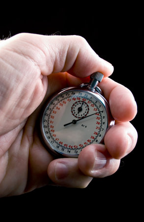 A man holding a stop watch in his hand as if timing some activity of some sort. 