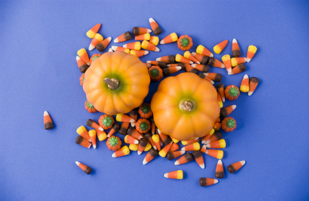 Two little pumpkins surrounded by colorful candy. の写真素材