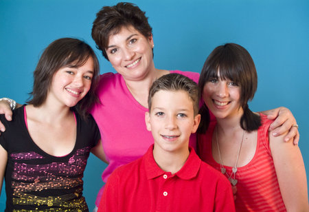 A woman and three adolescent children representing a happy family. (blue screen)の写真素材