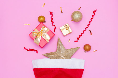 Happy new year 2021. Christmas toys, gift boxes, red cap, on a pink background. Christmas.の写真素材