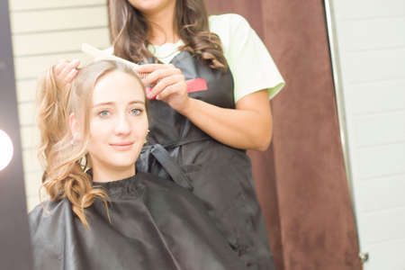 A young woman gets her hair done in a beauty salon. Barbershopの写真素材