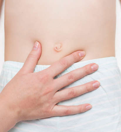 The surgeon examines the patient's abdominal cavity for the presence of an umbilical hernia. The concept of an abdominal wall disease with an umbilical hernia. Stomach pain.の写真素材