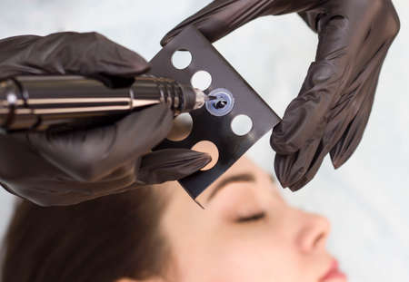 Permanent makeup. Permanent eyebrow tattoo. Cosmetologist applying permanent makeup on eyebrows - eyebrow tattoos. Tattooing. Microblading.の写真素材