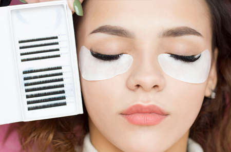 Eyelash extensions. Artificial eyelashes. The girl in the salon is doing an eyelash extension procedure. Close-up.の写真素材