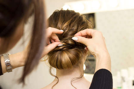The stylist performs the hairstyle, hair styling in the salon.の写真素材
