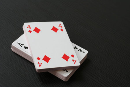 Four of tiles (diamonds) and ace of clubs (clovers) on the top of the playing card deck