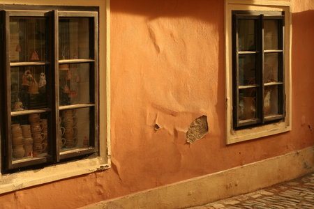 Almost abandoned building with orange ruptured facade and beautiful brown wooden windows. Vintage view in the center or historical town of Kutna Horaの写真素材