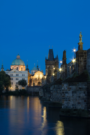 The church of Saint Francis of Assisi church during dusk blue hour. Old Town Tower of Charles bridge. Gothic bridge with baroque statues.の写真素材