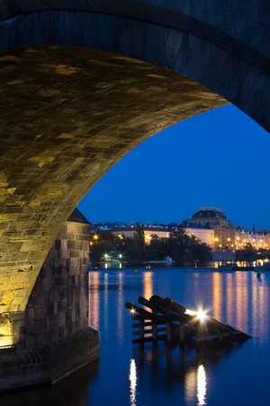 Second arch of the Charles bridge with Vltava river and bankside on the opposite side with the National Theater. Night picture of the embarkment and the National theater often called golden chapelの写真素材