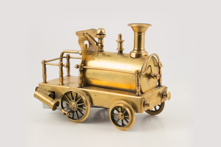 Old golden toy steam locomotive on isolated backgroundの写真素材