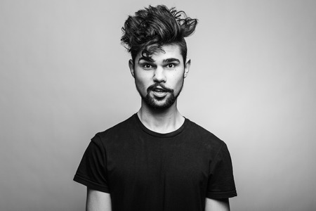 young handsome man doubting isolated over gray backgroundの写真素材