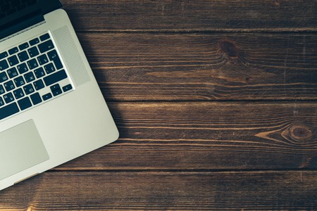 Laptop keyboard on the brown wooden deskの写真素材