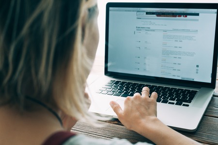 Woman working with laptop placed on the wooden deskの写真素材