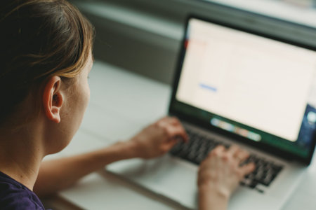 Woman working with laptop placed on the wooden desk