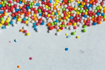 colorful sugar balls sprinkled  on a white background with copyspase, top view.の写真素材