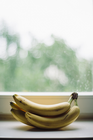 a bunch of ripe bananas lying by the windowの写真素材