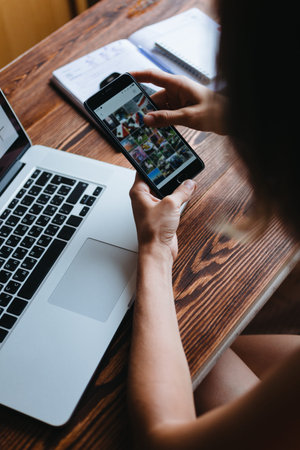 Young woman working on the computer, and something looks in the phone