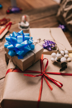 From above view of small wrapped presents decorated with colorful ribbons on wooden desk.