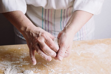 Close-up view of two womans hands making meat dumplings.の写真素材
