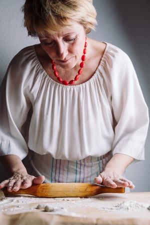 Front mid view of womans hands making meat dumpling with wooden rolling pin.の写真素材