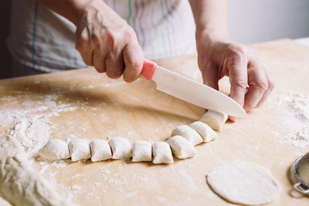 Front view of womans hands making dough for meat dumplings.の写真素材