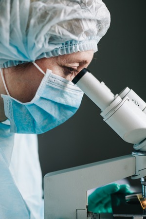 Close up view of scientist eye looking at microscope.の写真素材