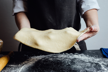 Hands of cook working with rolled shortcrust doughの写真素材