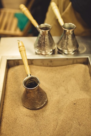 Jezve for coffee brewing placed in the sand in coffee shop.の写真素材