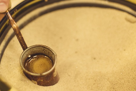 Jezve for coffee brewing placed in the sand in coffee shop.の写真素材