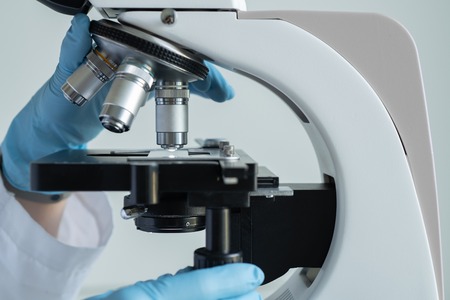 Scientist hands with microscope close-up shot in the laboratoryの写真素材