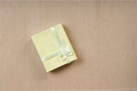 Green mini gift box with ribbon on gray backgroundの写真素材