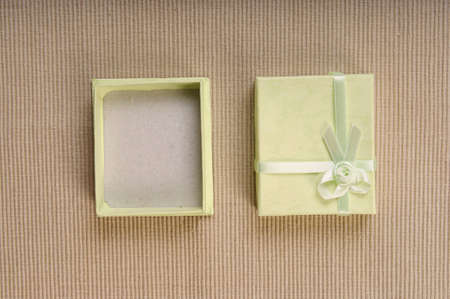 Green mini gift box with ribbon on gray backgroundの写真素材