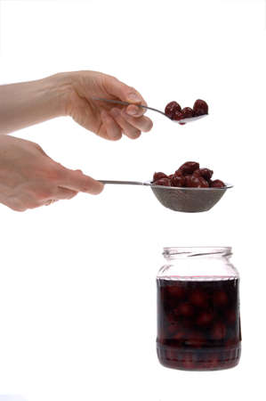 stoned cherry -  Home made cans of preserveson hand isolated on whiteの写真素材