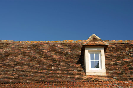 window in attic, garret, loft and blue skyの写真素材